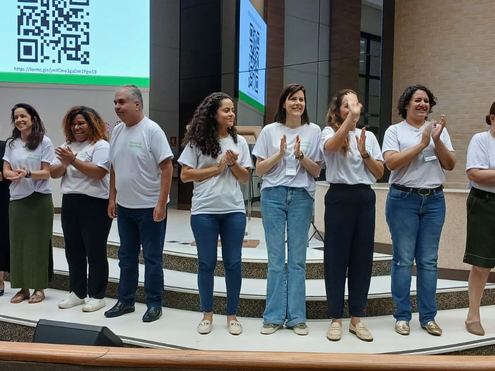 Equipe do Ministério Esperança reunida no palco da igreja, de camiseta branca