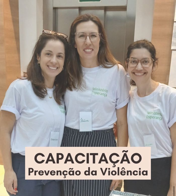 Voluntárias com a placa da capacitação sobre prevenção da violência