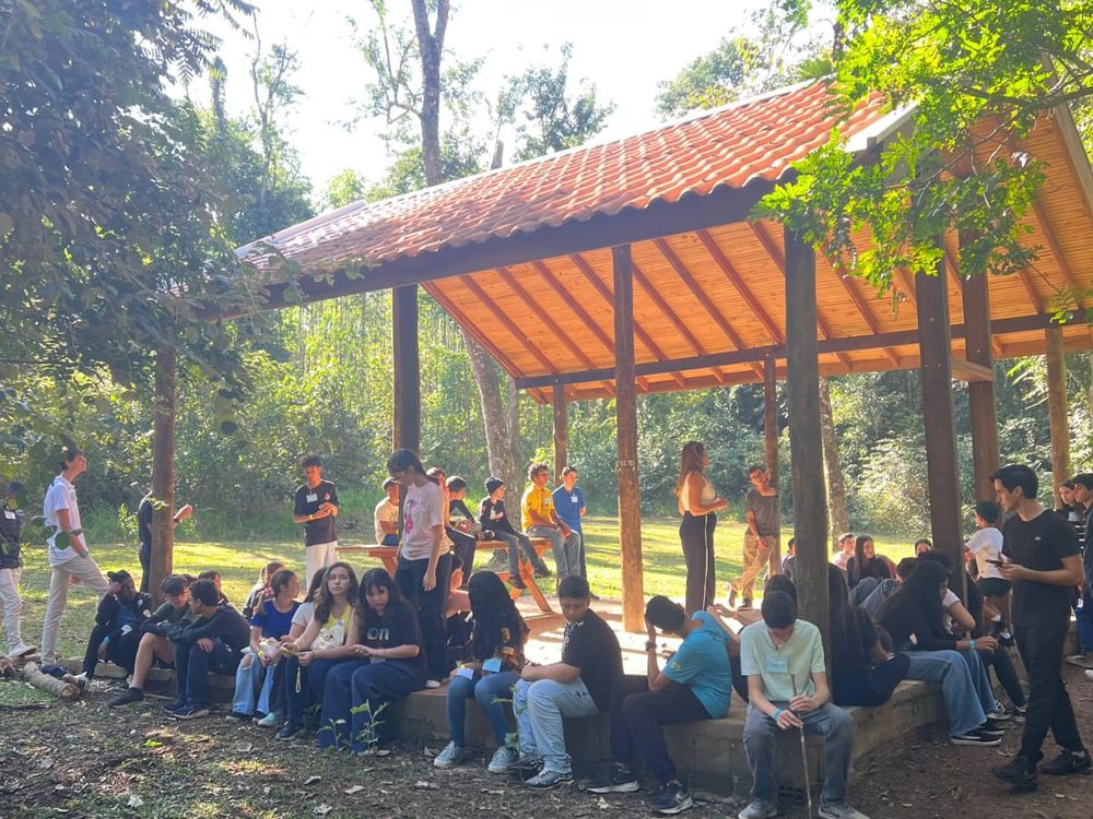 Grupo reunido sob um quiosque arborizado na sede adventista de Analândia