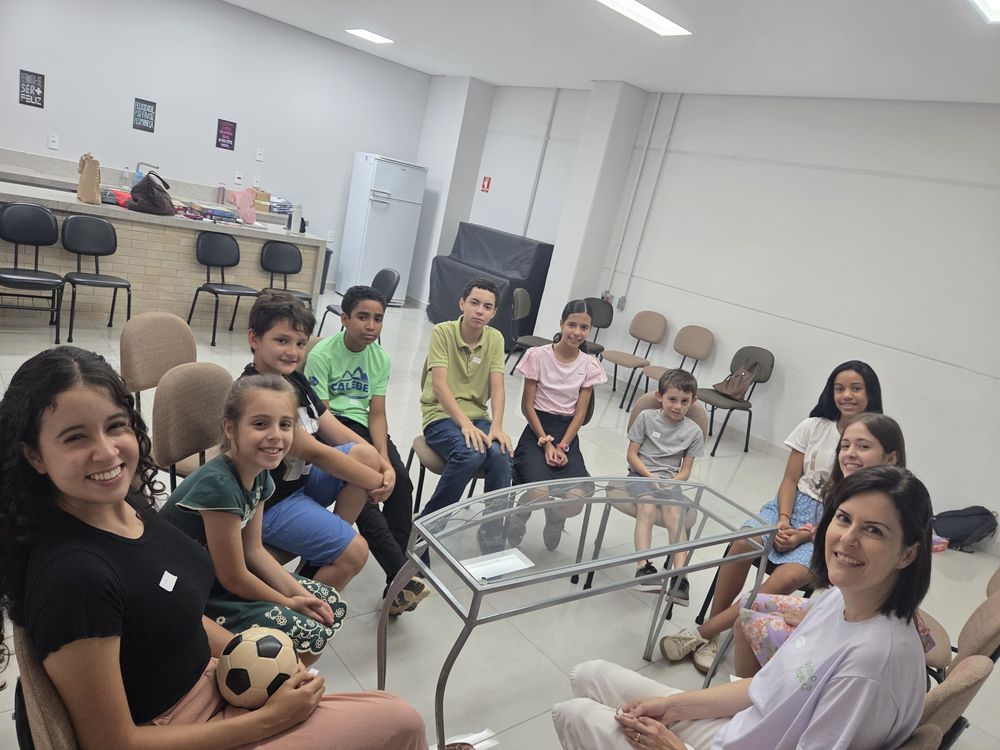 Adolescentes e educadoras sentados em roda, conversando durante um encontro