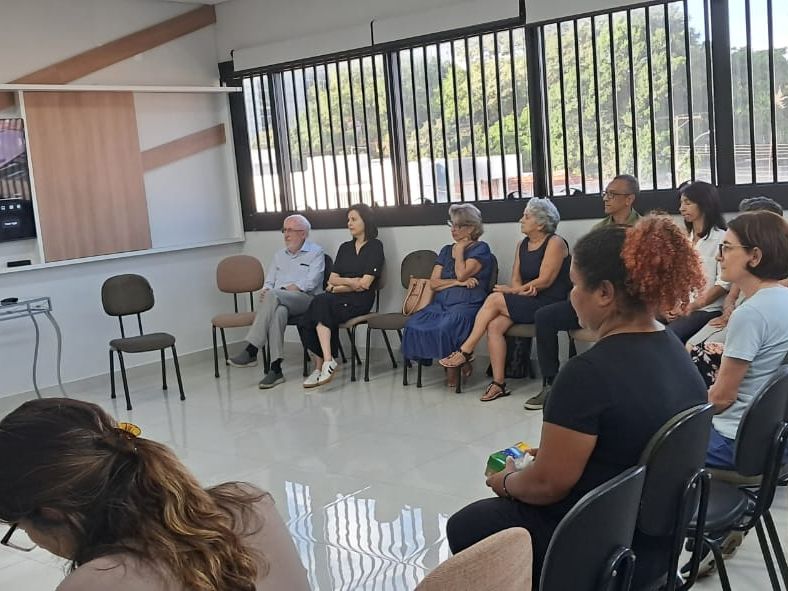 Roda de conversa com adultos sentados em círculo em uma sala clara