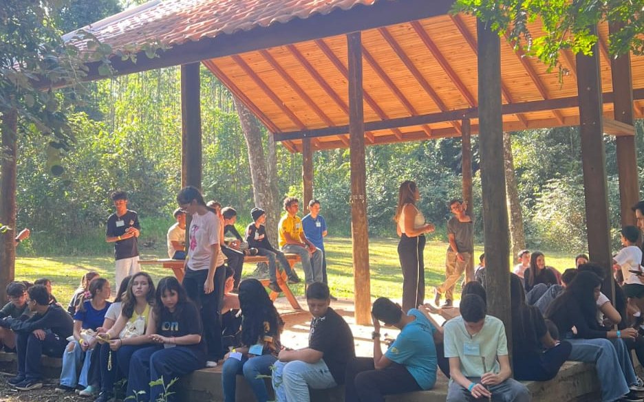 Adolescentes reunidos ao ar livre durante o encontro anual