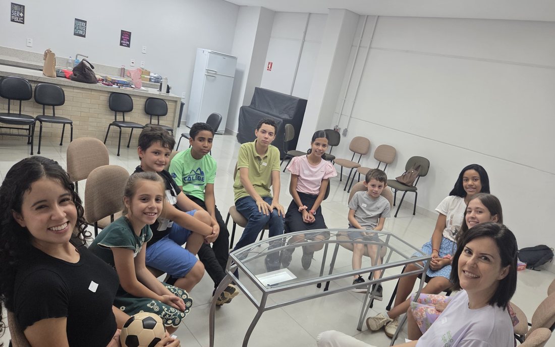 Crianças, adolescentes e voluntárias sentados em roda